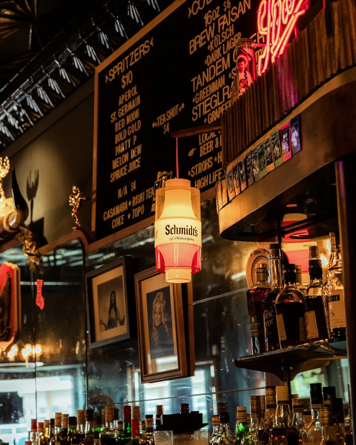 The bar menu, bottles, and neon inside Last Chance Saloon
