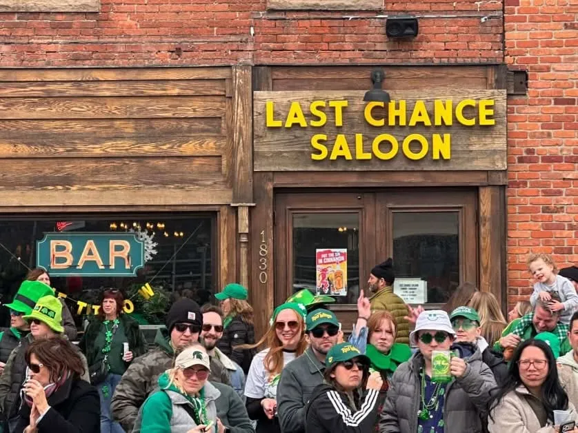 People gathered outside Last Chance Saloon beneath the yellow storefront sign